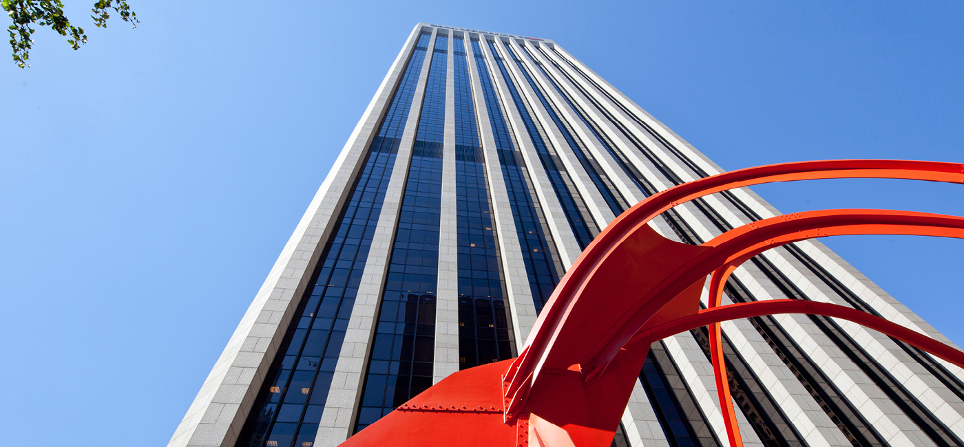Dramatic upward angle of Bank of America plaza with clear blue skies and a red sculpture in the foreground