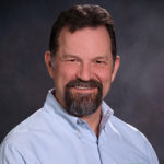 Portrait of Randy Glardon in a light blue collared shirt with brown hair and a goatee