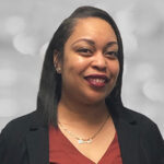 Shondrea is the new Associate Real Estate Manager. She has dark, straight shoulder length hair and she's wearing a black blazer with a brown top and a gold necklace.